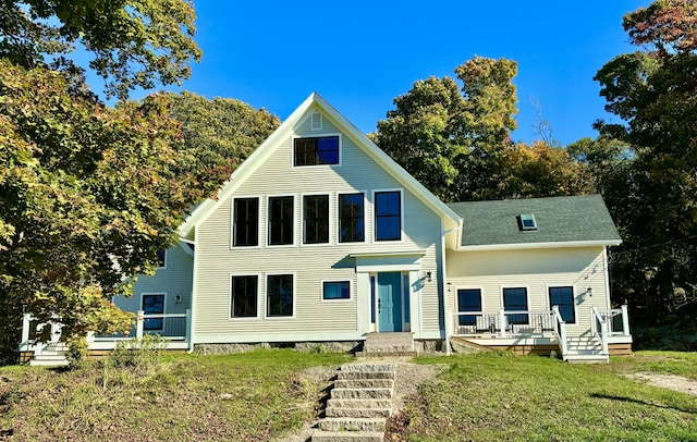 view of front of house with a deck and a front yard