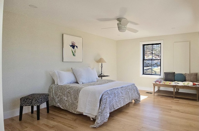 bedroom featuring ceiling fan, baseboards, visible vents, and light wood-style flooring