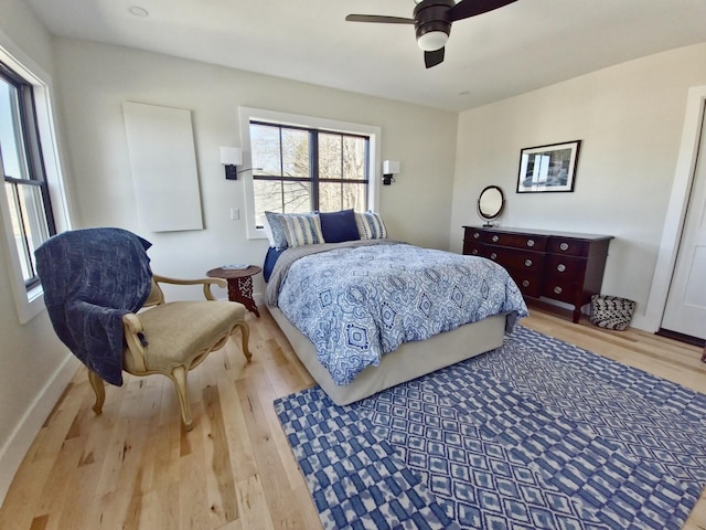 bedroom featuring ceiling fan, baseboards, and wood finished floors
