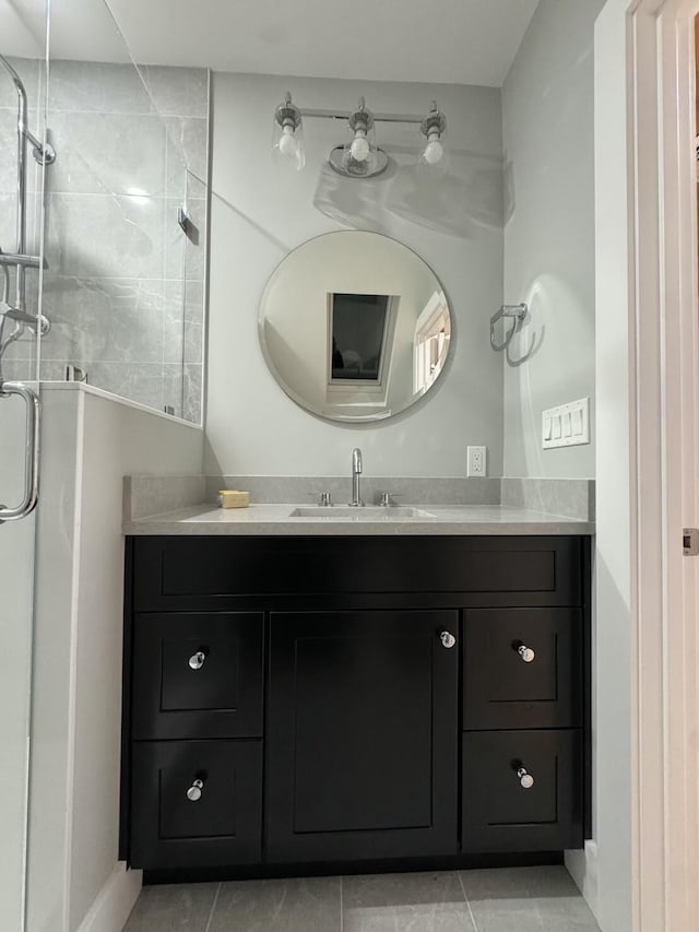 bathroom featuring baseboards, vanity, tile patterned flooring, and a shower stall