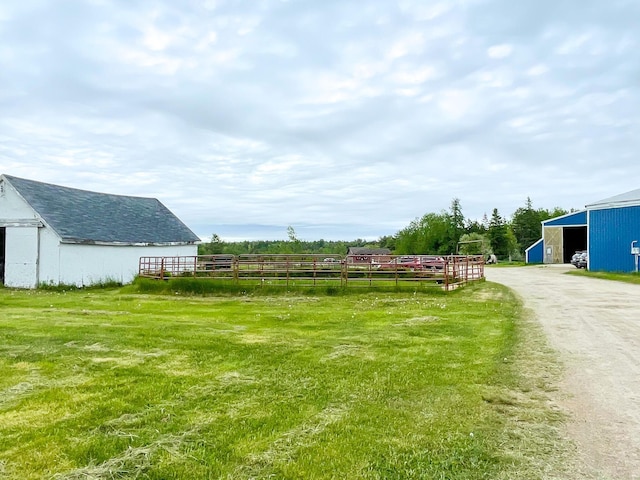 view of yard featuring a rural view and an outbuilding