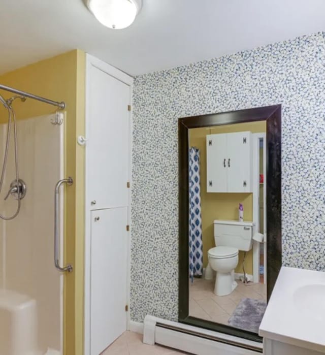 bathroom with toilet, vanity, tile patterned flooring, a baseboard heating unit, and curtained shower