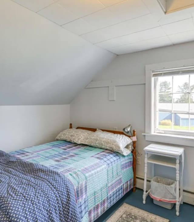 bedroom featuring a baseboard heating unit and lofted ceiling