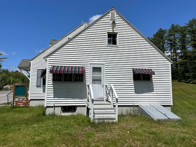 rear view of house featuring a lawn