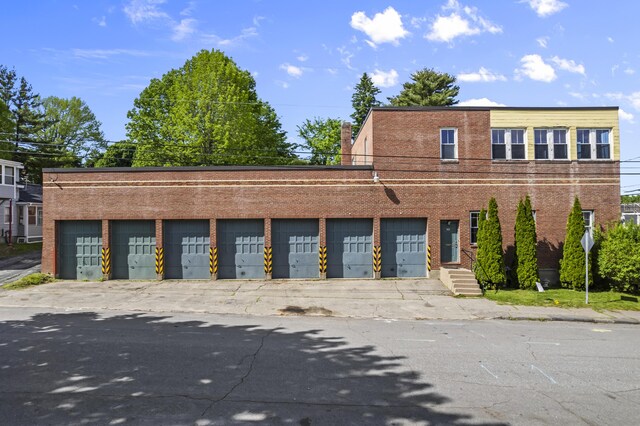 view of front of home featuring community garages and brick siding