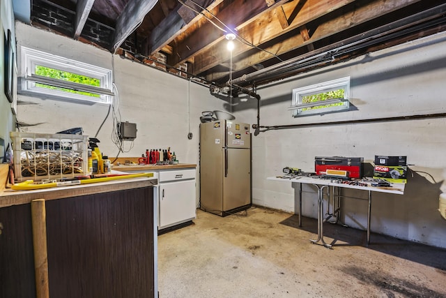 basement with a workshop area and freestanding refrigerator