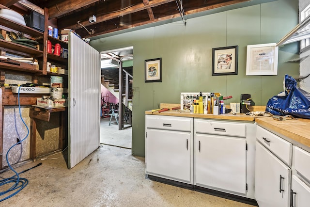 kitchen with white cabinets and concrete floors