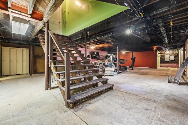 unfinished basement with electric panel and stairway
