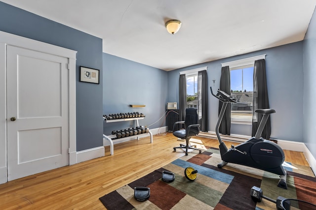 exercise area with baseboards and wood-type flooring