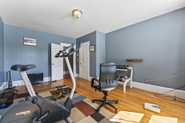workout room with baseboards and wood finished floors