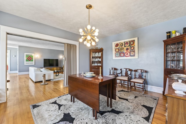 office space with light wood finished floors, baseboards, and a textured ceiling