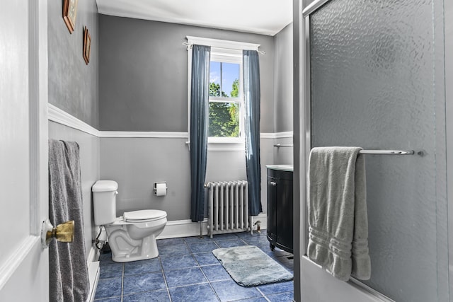 bathroom featuring tile walls, toilet, a shower with door, a wainscoted wall, and radiator heating unit
