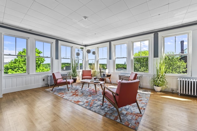 sunroom with radiator, a deck, and hardwood / wood-style flooring