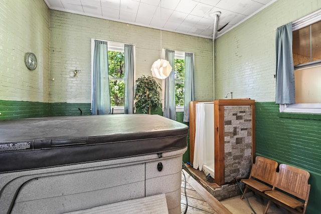 misc room featuring brick wall