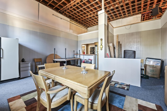 carpeted dining room with a high ceiling