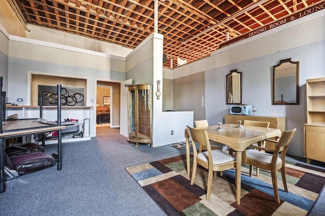 dining space with a towering ceiling and carpet