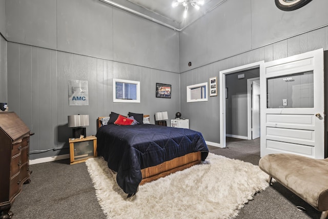 bedroom with a high ceiling, carpet floors, and baseboards