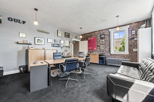 home office with radiator, brick wall, and a textured ceiling