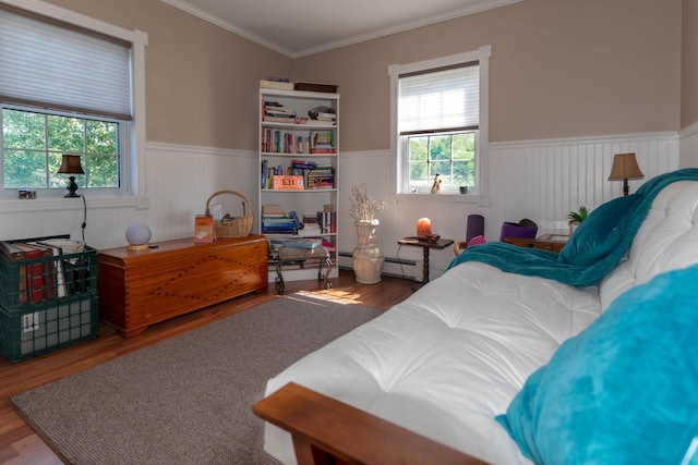 bedroom with a baseboard radiator, ornamental molding, and hardwood / wood-style floors