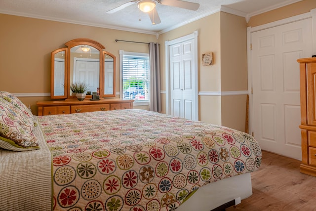 bedroom with ceiling fan, a textured ceiling, light hardwood / wood-style flooring, and ornamental molding