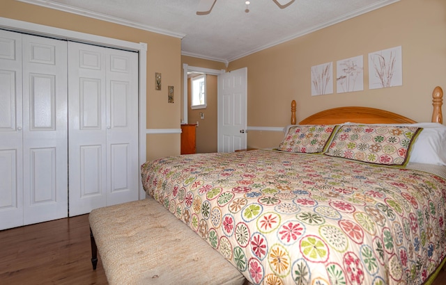 bedroom featuring ceiling fan, dark wood-type flooring, a closet, and crown molding