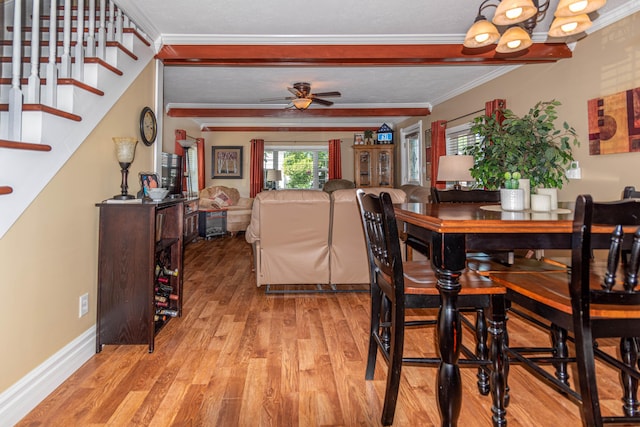 dining area with ornamental molding, ceiling fan with notable chandelier, and light hardwood / wood-style flooring