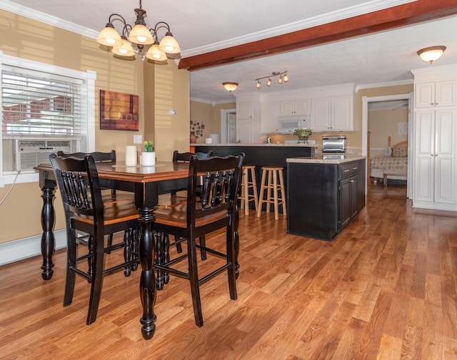 dining room with light wood-type flooring, a chandelier, crown molding, and cooling unit