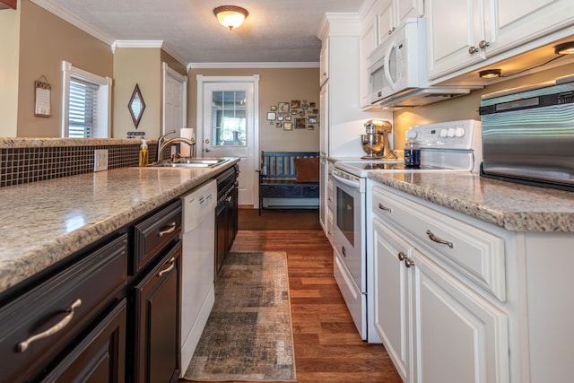 kitchen featuring dark wood-type flooring, white cabinetry, crown molding, and white appliances