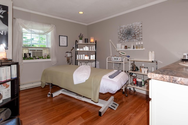 bedroom featuring wood-type flooring, a baseboard heating unit, and ornamental molding