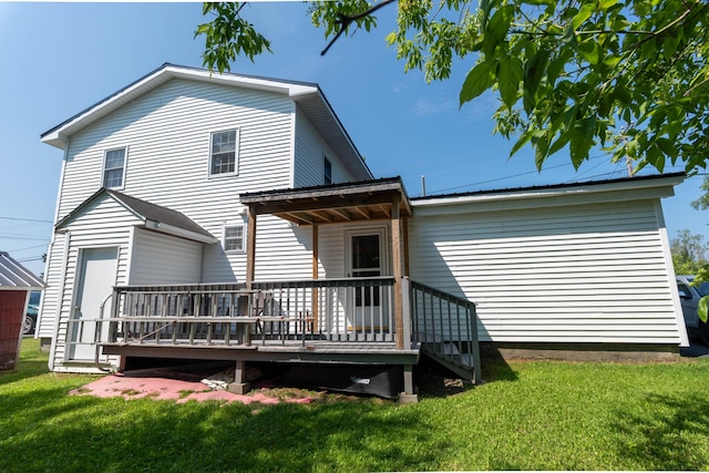 rear view of house with a deck and a lawn