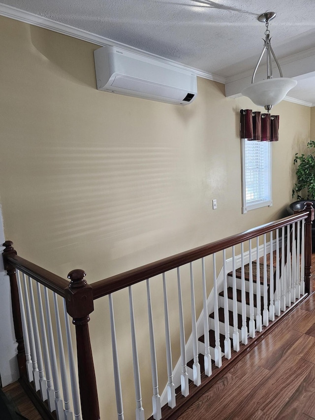 176 Market St, Fort Kent, ME 04743 - stairway featuring a wall mounted air conditioner, ornamental molding, wood finished floors, and a textured ceiling
