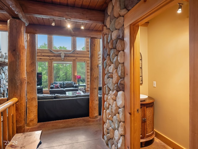 interior space featuring beam ceiling, wooden ceiling, and log walls