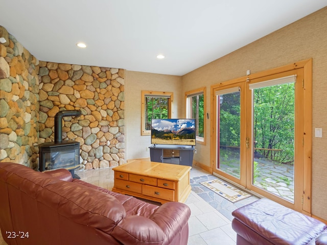 living room featuring a wood stove and light tile patterned floors