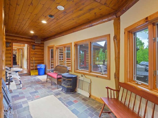 sunroom with wooden ceiling and a wood stove