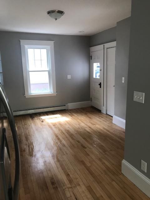 foyer featuring hardwood / wood-style floors and a baseboard radiator