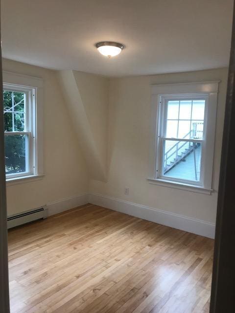 bonus room featuring light hardwood / wood-style floors and a baseboard radiator