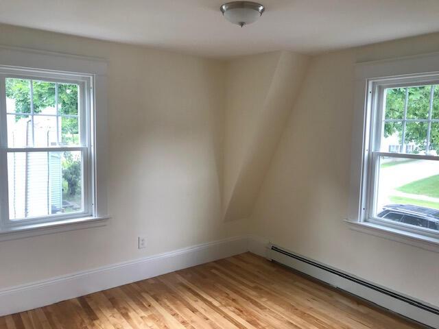 spare room with light wood-type flooring and baseboard heating