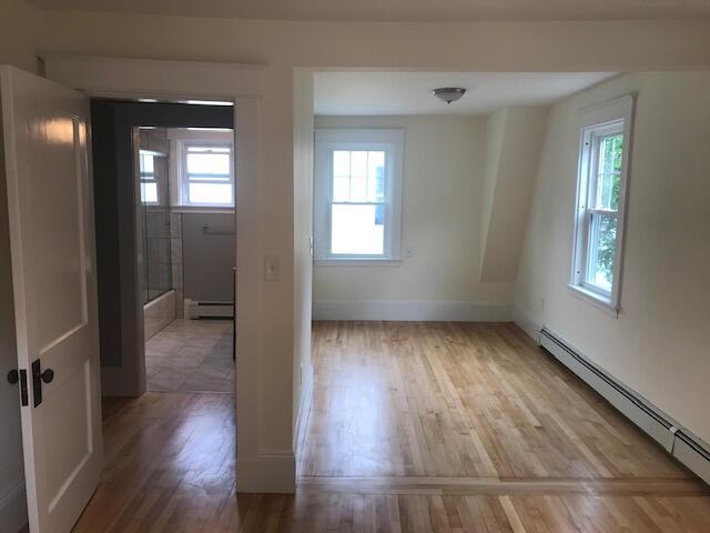 interior space with baseboard heating, a healthy amount of sunlight, and light hardwood / wood-style flooring