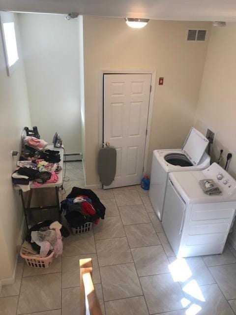 laundry room with baseboard heating, light tile patterned floors, and independent washer and dryer