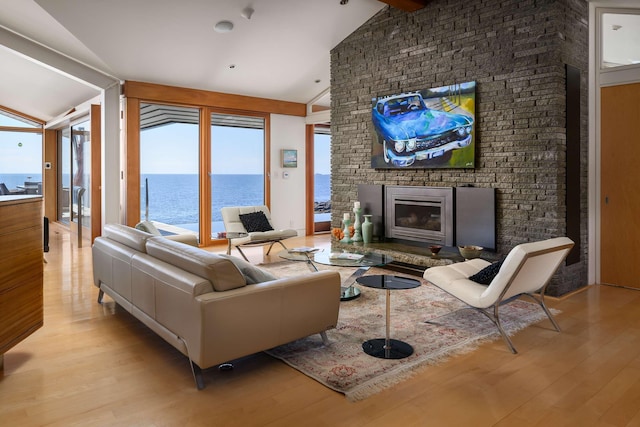 living room featuring high vaulted ceiling, a fireplace, and light wood-type flooring