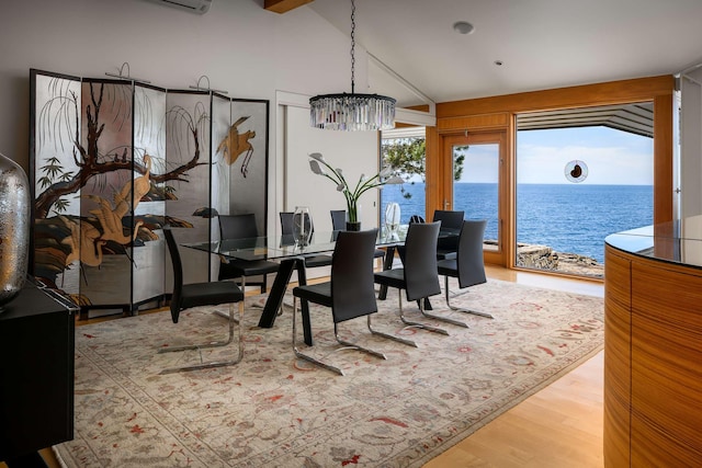 dining room with a water view, lofted ceiling, and wood-type flooring