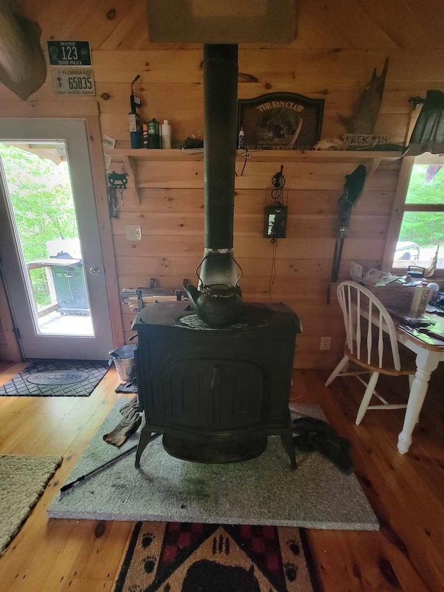 interior details featuring wood walls, a wood stove, and hardwood / wood-style flooring