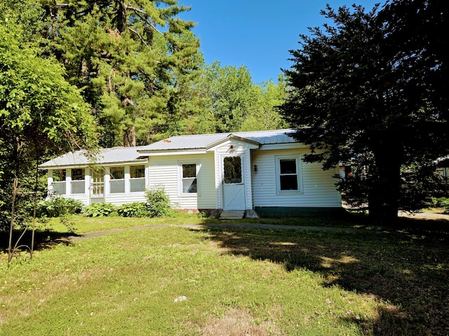 view of front facade with metal roof and a front lawn