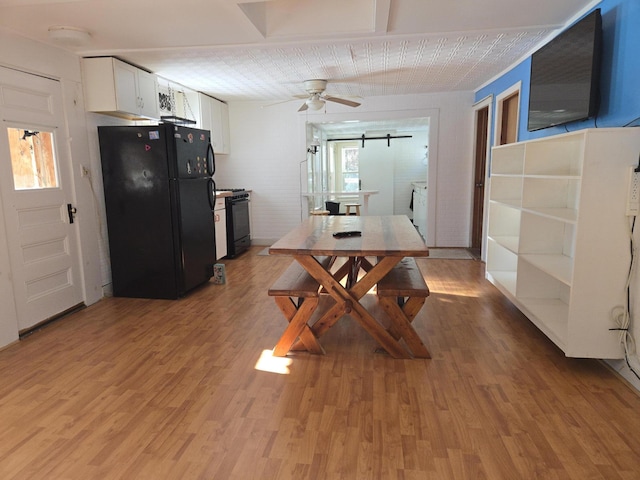 dining space featuring light wood finished floors and ceiling fan