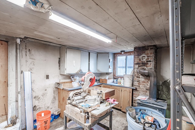 interior space featuring a wood stove and brick wall