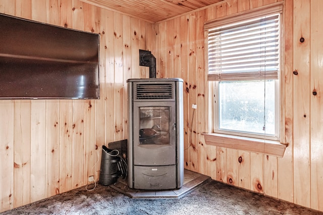 kitchen with carpet, wood walls, and a wood stove