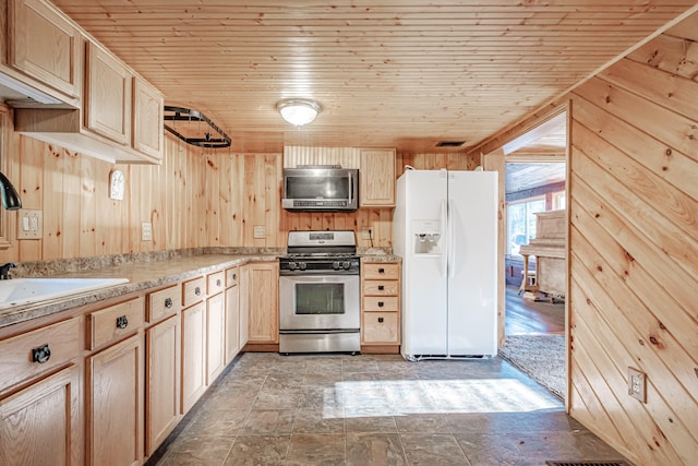 kitchen featuring wooden walls, light brown cabinets, wood ceiling, and appliances with stainless steel finishes