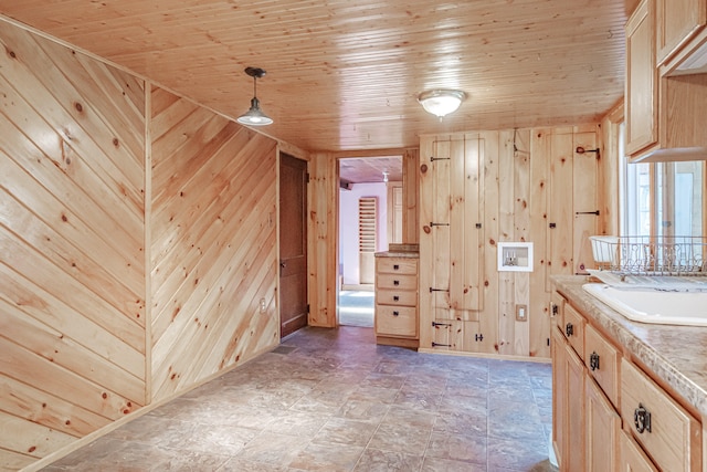 bathroom with wooden ceiling, sink, and wooden walls