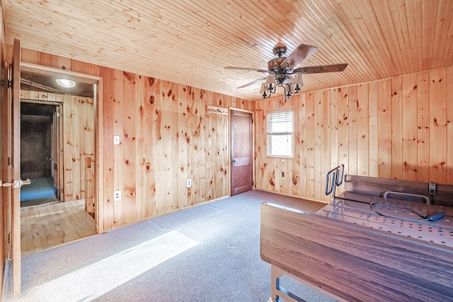 misc room with carpet flooring, wooden ceiling, ceiling fan, and wooden walls