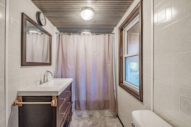 bathroom with tile patterned flooring, vanity, toilet, and tile walls